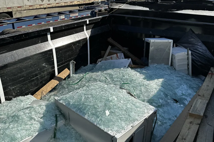 Dump trailer loaded with broken glass and lumber by ONIT Junk Removal