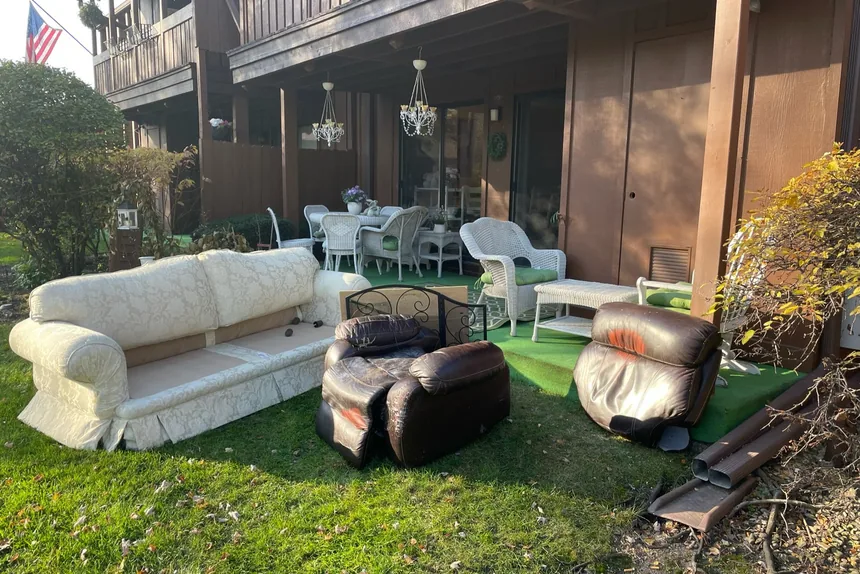 Old sofa and recliners on lawn before furniture removal by ONIT Junk Removal