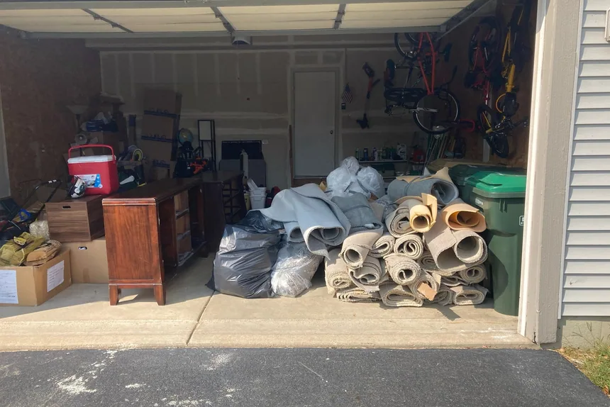 Cluttered garage with old rolled carpet before a cleanout by ONIT Junk Removal