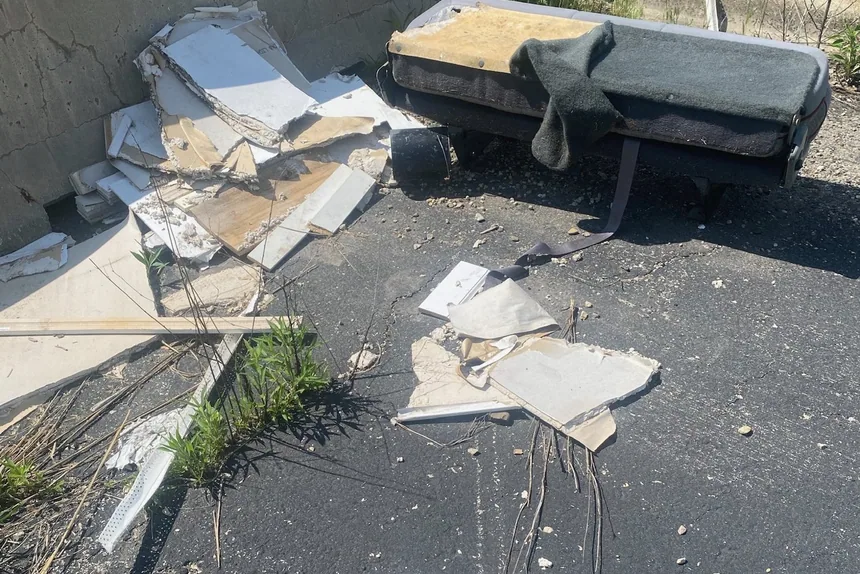 Debris and old mattress on pavement before junk removal by ONIT Junk Removal