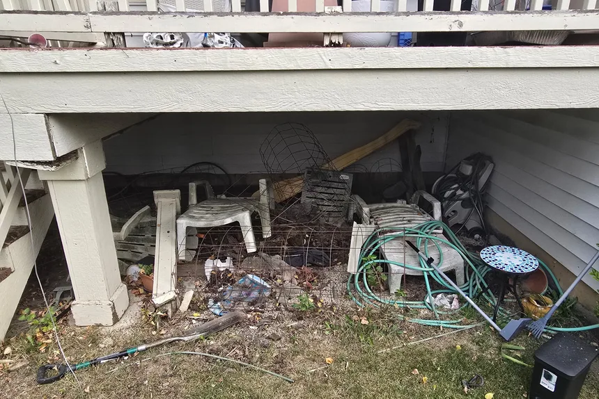 Clutter under a backyard deck before yard waste removal by ONIT Junk Removal